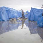 20100226cnsnw01142 1 150x150 - MAN WALKS AT WATERLOGGED TENT CAMP IN PORT-AU-PRINCE
