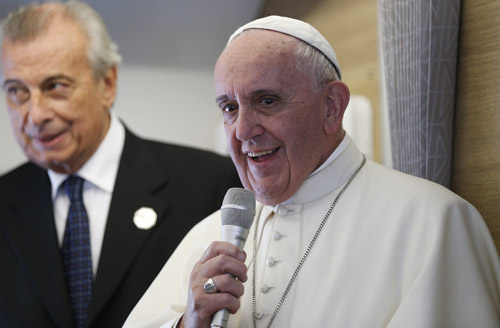 Meeting reporters on plane, pope defends his teaching on social issues