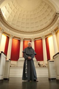 Father Linus DeSantis, OFM Conv., stands in Syracuse University's Hendricks Chapel. (Photo by Riley Woods Photography)