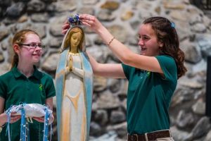 Sixth graders, Mary Lousie Pemfield, left and Nikki Limer,12, from All Saints School Thursday crowned the Blessed Mother at the Marian Shrine at St. Joseph Church in Endicott. Their essays about the Blessed Mother were picked for the honor of placing the crown of flowers. -Sun photos | Chuck Haupt