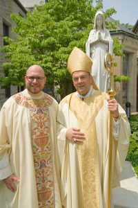 Father Brooks and Bishop Cunningham stop for a photo in the Cathedral prayer park following the ordination Mass. (Sun photos | Chuck Wainwright)