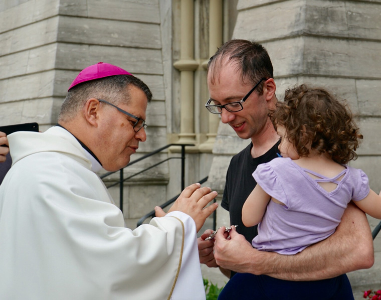 Bishop-elect Lucia blesses Bennett McLoughlin and daughter Emeline following Mass at the Cathedral of the Immaculate Conception