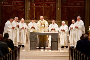 Concelebrates Mass with Bishop Robert J. Cunningham and several priests of the diocese