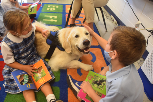 dog with kids - Bishop Lucia reads to kindergartners at IC School in Fayetteville