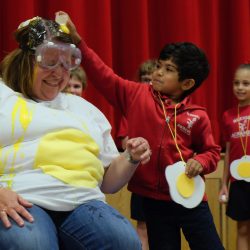 Blessed Sacrament School Principal Andrea Polcaro gets egged June 13. She promised her students they could egg her if they read 20,000 books over the course of the school year. (Sun photo | Chuck Wainwright)