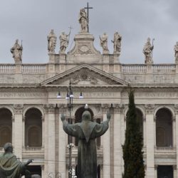 Viewed from a nearby park, a statue of St. Francis appears to “hold up” the Basilica of St. John Lateran. (Sun photo | Katherine Long)